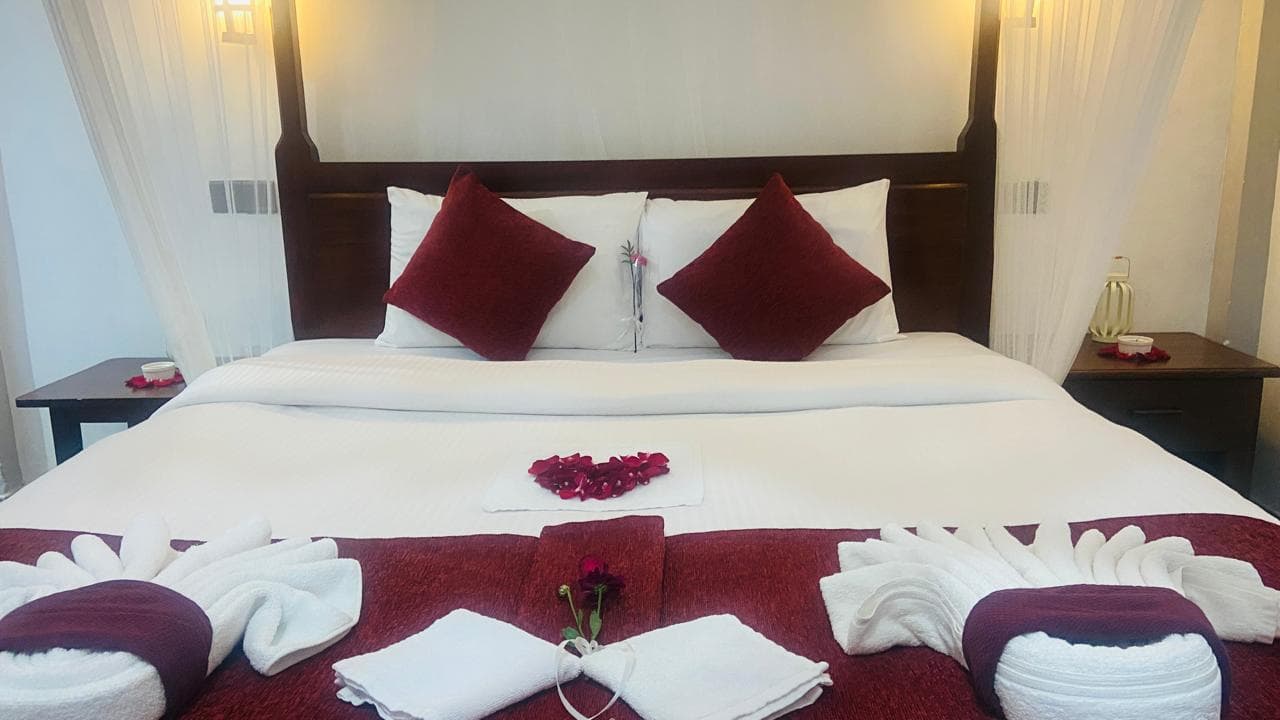 Hidden Cove queen canopy bed dressed with rose petals and folded towels