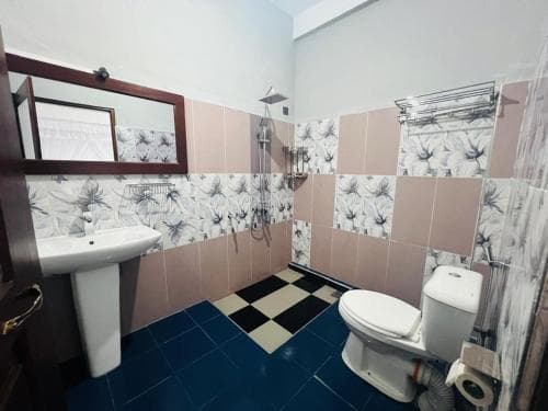 Hidden Heaven bathroom with floral tiles, basin and toilet