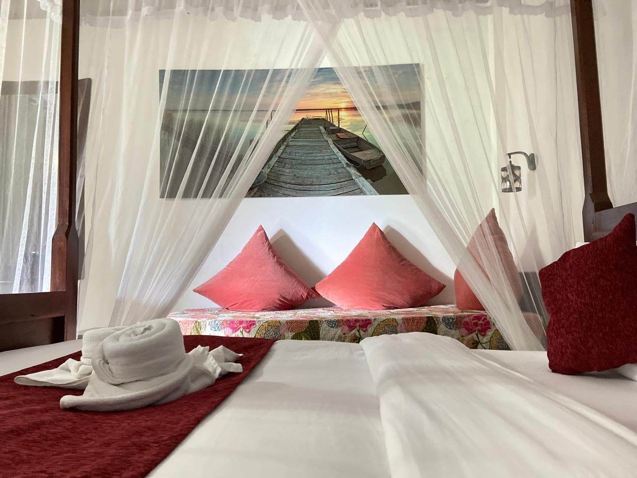 Hidden Heaven canopy bed with a sunset jetty artwork above the daybed