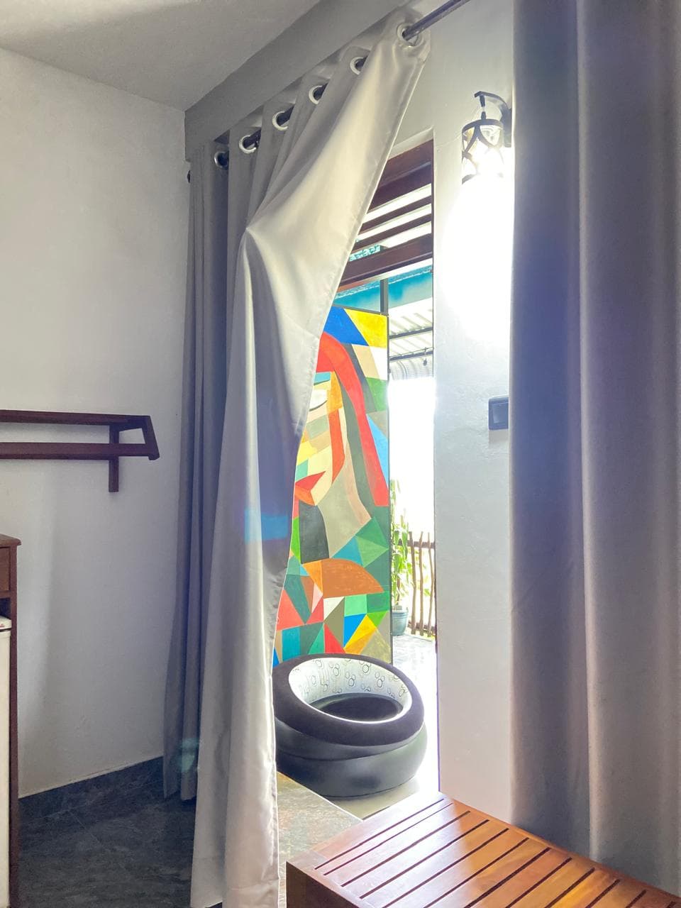 Curtained doorway opening onto the Hidden Heaven balcony mural